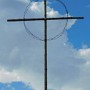 Dřevěný kříž s ostnatým drátem v Lidicích.